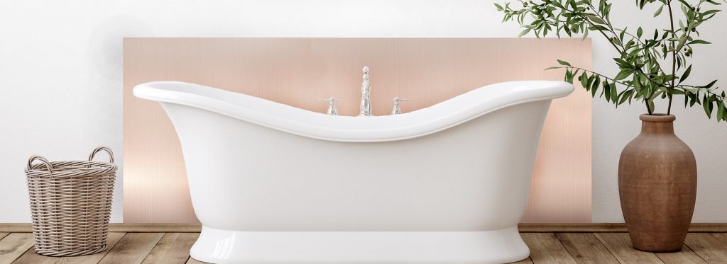 Rose gold splashback in traditional bathroom with white roll top bath and greenery. 