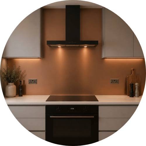 Brushed copper aluminium splashback in a modern kitchen featuring a sleek metallic finish, handleless cabinetry, black extractor hood, warm LED lighting, and contemporary neutral interior styling.